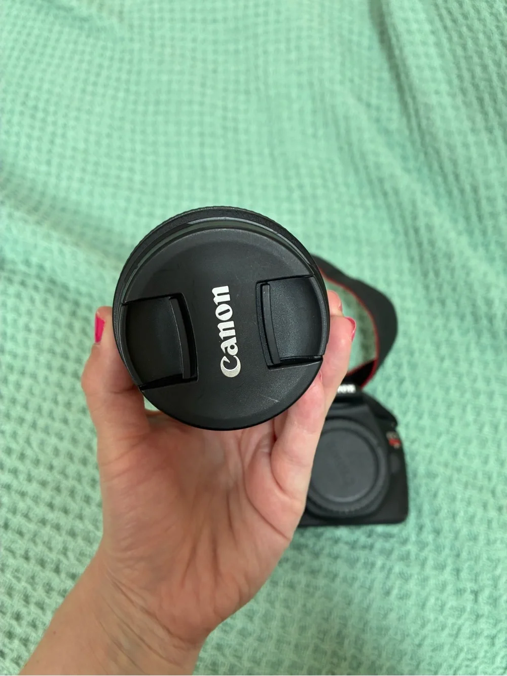 Canon DSLR Camera Body in Black with Red Strap Accents and kit lens.